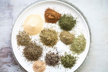 A plate with greek seasoning spices on it.