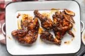 Barbecue chicken on a white platter.