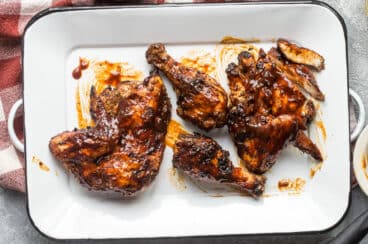 Barbecue chicken on a white platter.