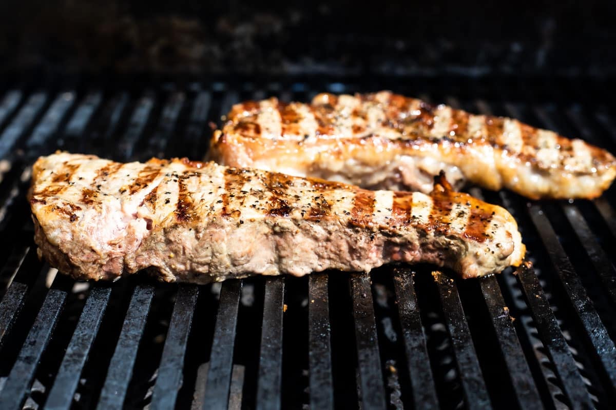 New York strip steaks on the grill.