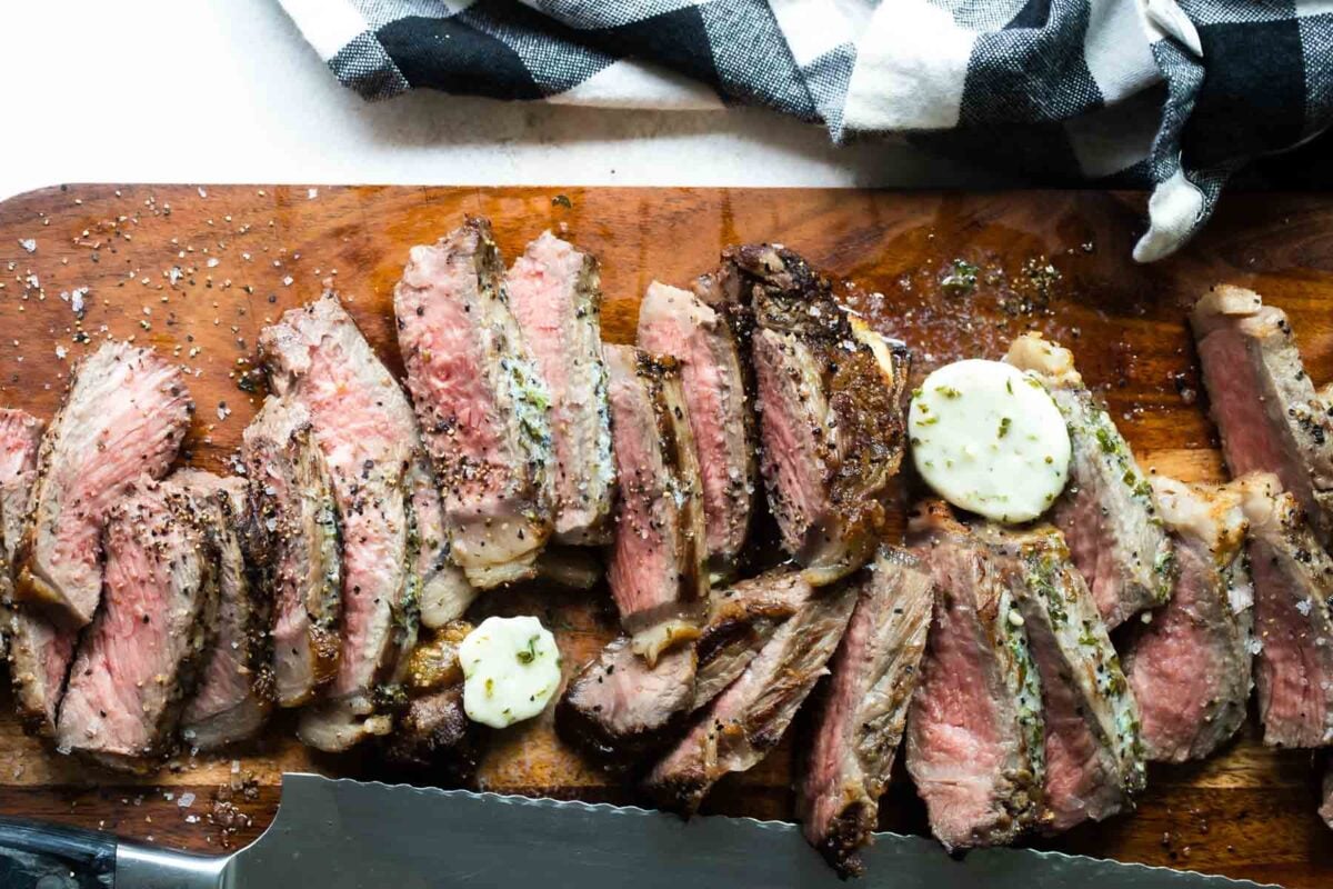 Sliced New York strip steaks on a cutting board.