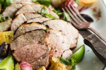 Grilled pork tenderloin slices on a white platter.