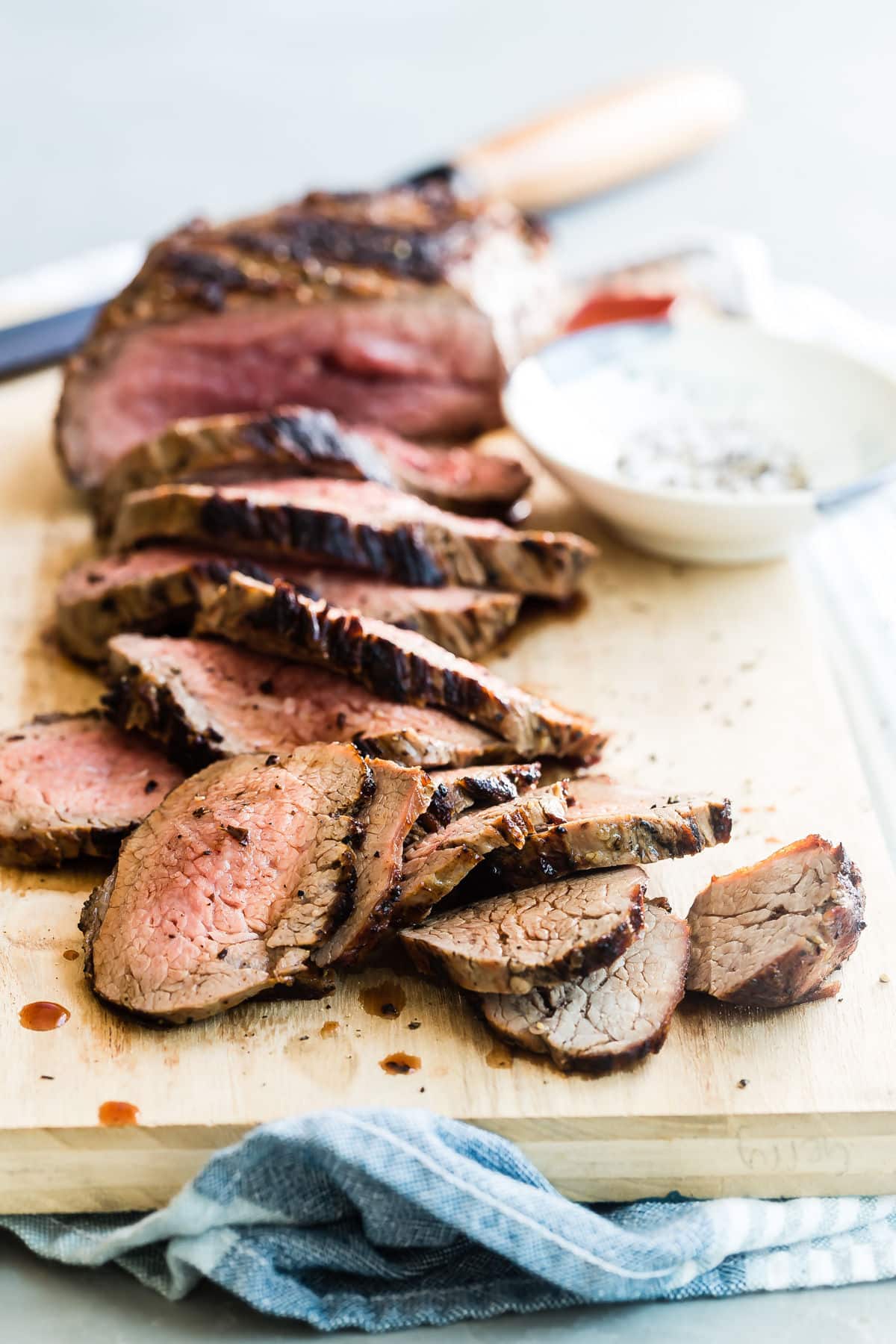 A cutting board with a sliced tri tip on top.