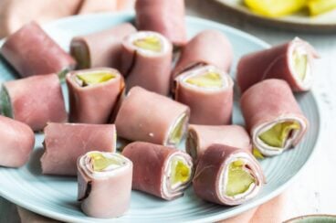 Ham roll ups on a light blue plate.