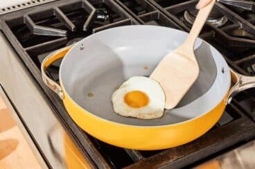 Someone getting ready to flip an egg in a frying pan.