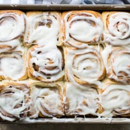 Homemade cinnamon rolls on a baking sheet.