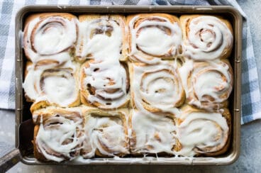 Homemade cinnamon rolls on a baking sheet.