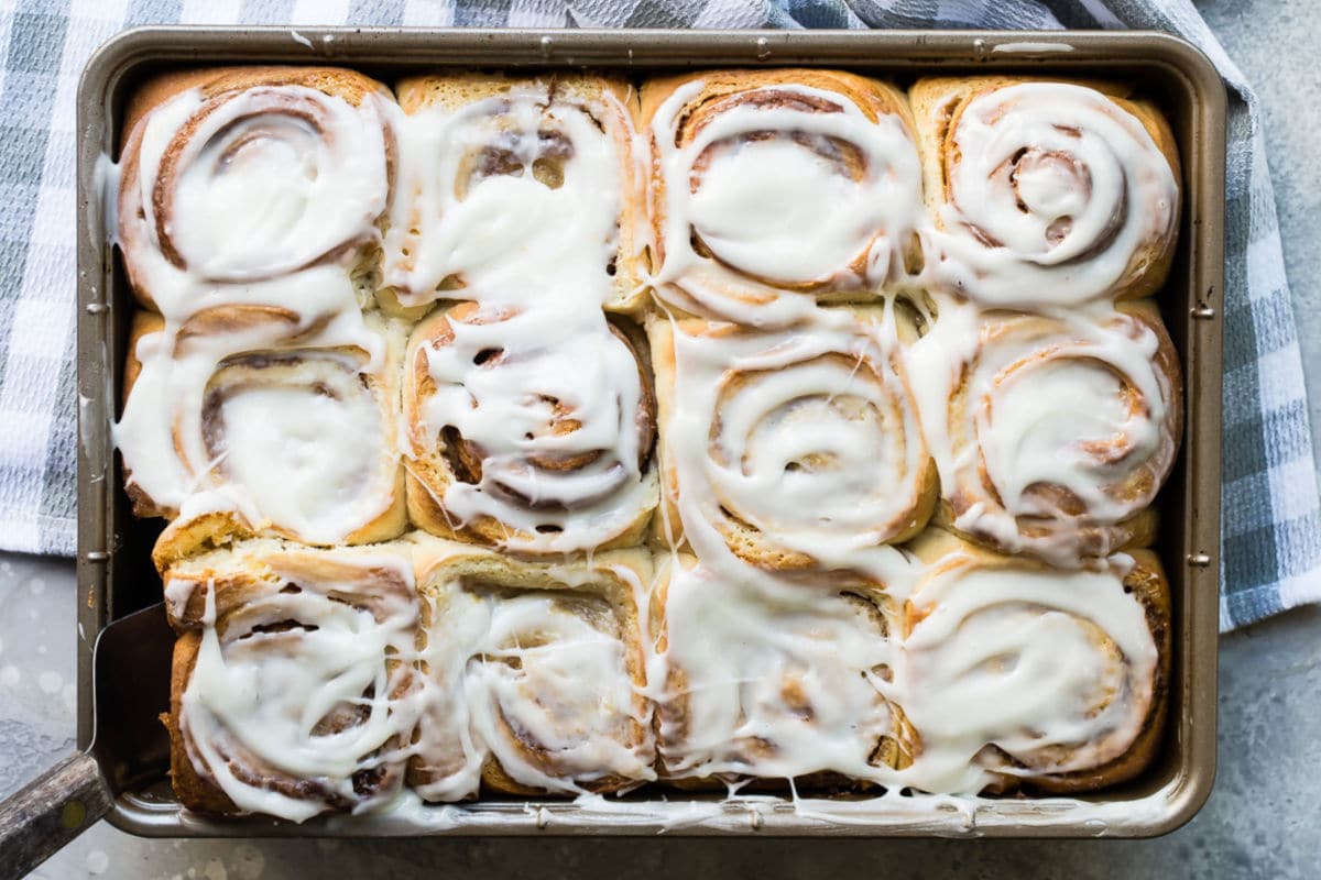 Homemade cinnamon rolls on a baking sheet.