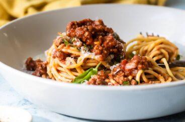 Spaghetti with sauce in a white bowl.