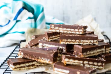 A stack of homemade Twix bars on a cooling rack.