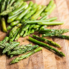 Chopped asparagus on a wood cutting board.