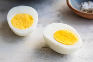 A hard boiled egg sliced in half lengthwise.