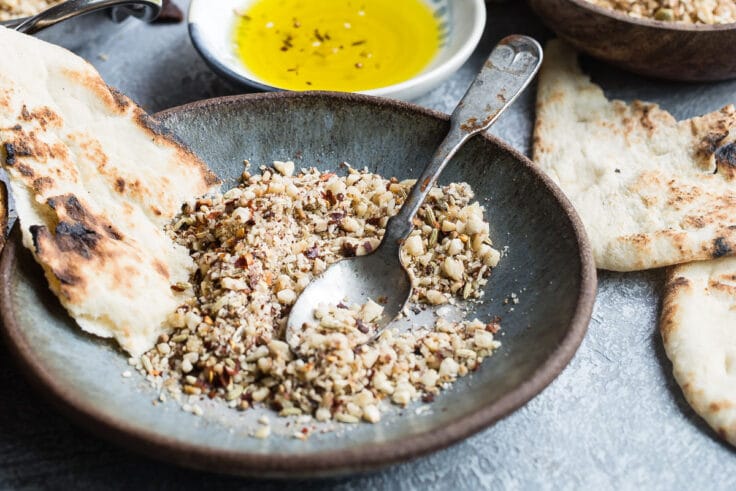 Dukkah on a blue plate with pita bread.