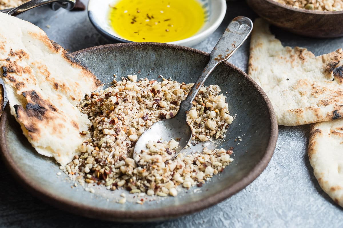 Dukkah on a blue plate with pita bread.
