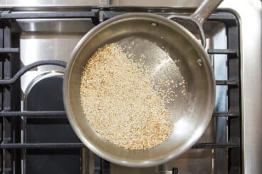 Sesame seeds toasting in a skillet.