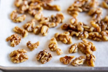 Toasted walnuts on a baking sheet.