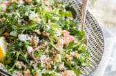 Israeli Couscous salad on a white and black platter.