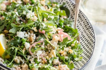 Israeli Couscous salad on a white and black platter.