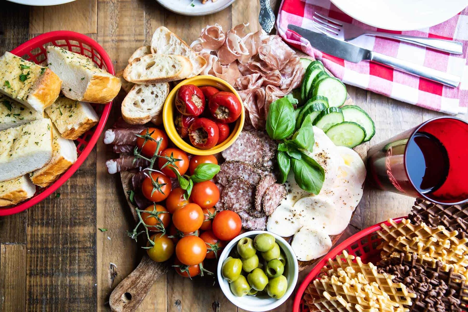 An antipasto platter on a wooden tray.
