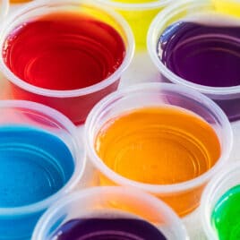 Various colored jello shots in clear portion cups.
