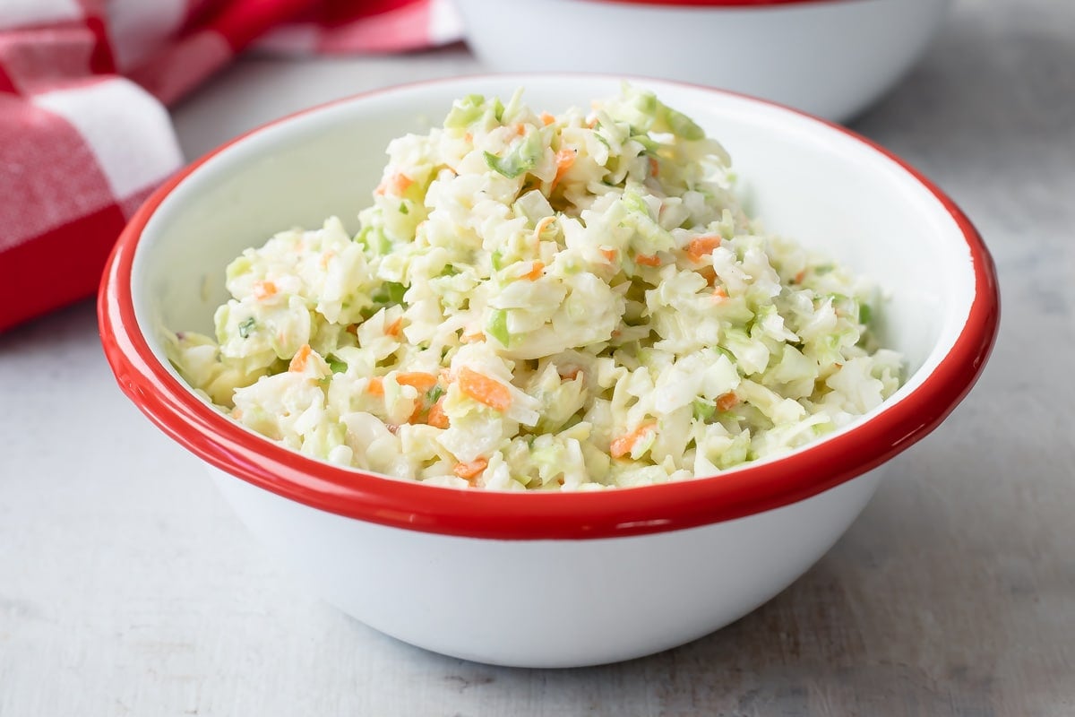 KFC coleslaw in a white bowl with a red rim.