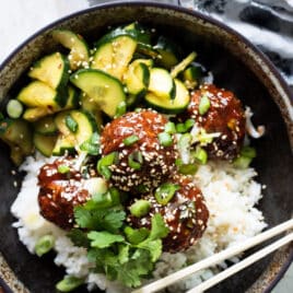 Korean barbecue meatballs, rice and cucumber in a gray bowl