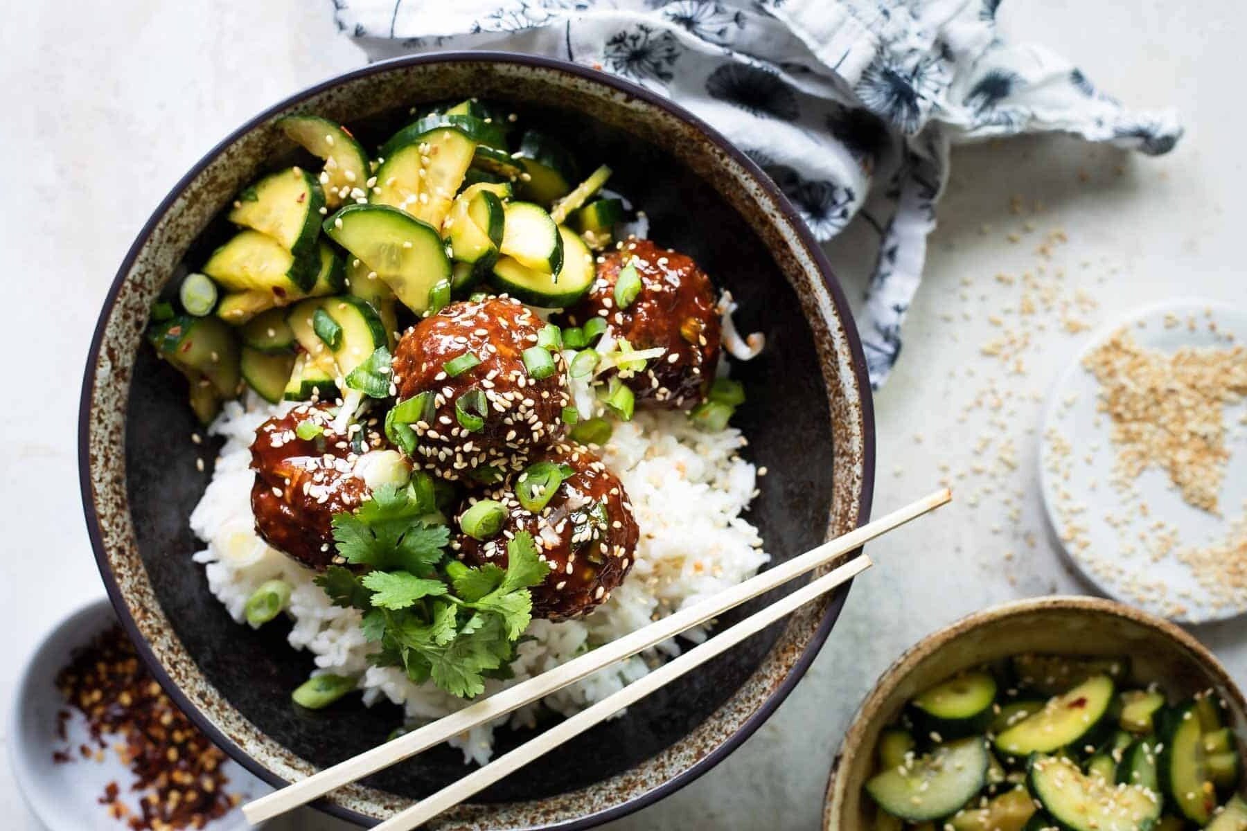 Korean barbecue meatballs, rice and cucumber in a gray bowl
