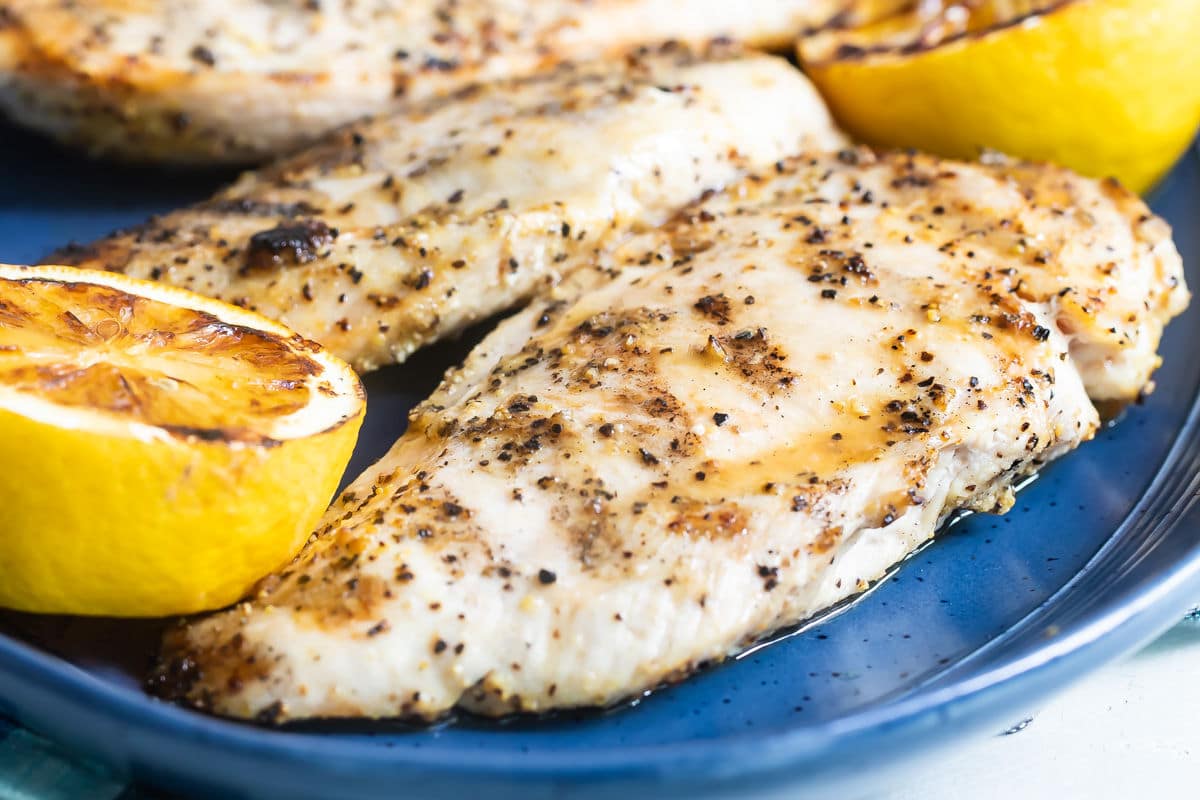 Lemon pepper chicken on a blue platter.
