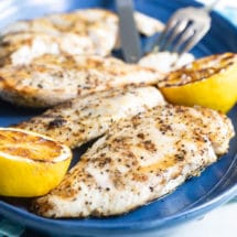 Lemon pepper chicken on a blue platter.