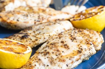 Lemon pepper chicken on a blue platter.