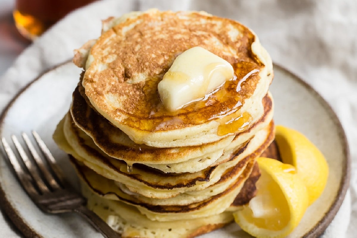 A stack of lemon ricotta pancakes on a plate.