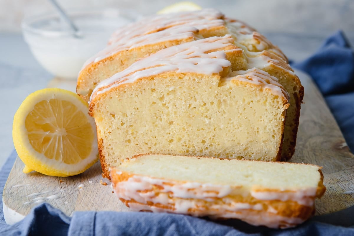 A lemon yogurt cake on a wooden cutting board.
