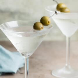 Two dry martinis garnished with green olives.
