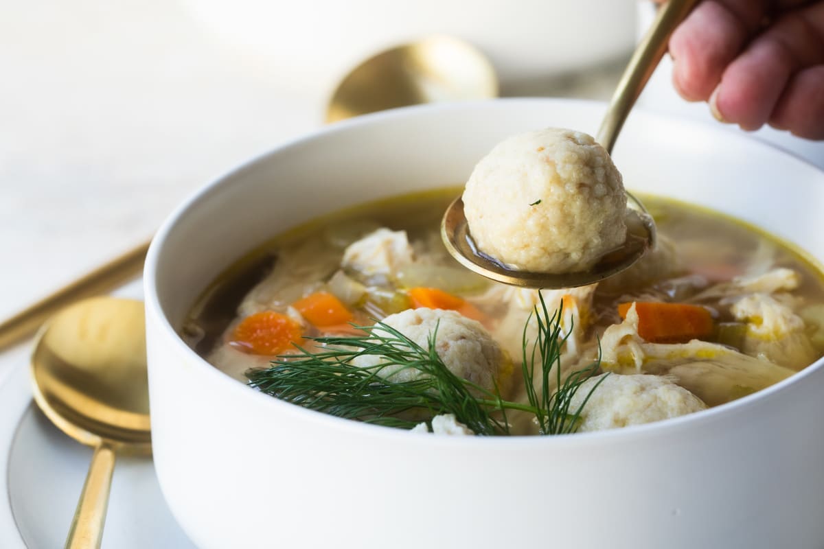 Someone scooping a Matzo ball out of a ball of Matzo ball soup.