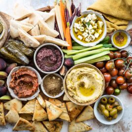 Dukkah, eggplant dip, hummus, artichokes, and olives in bowls