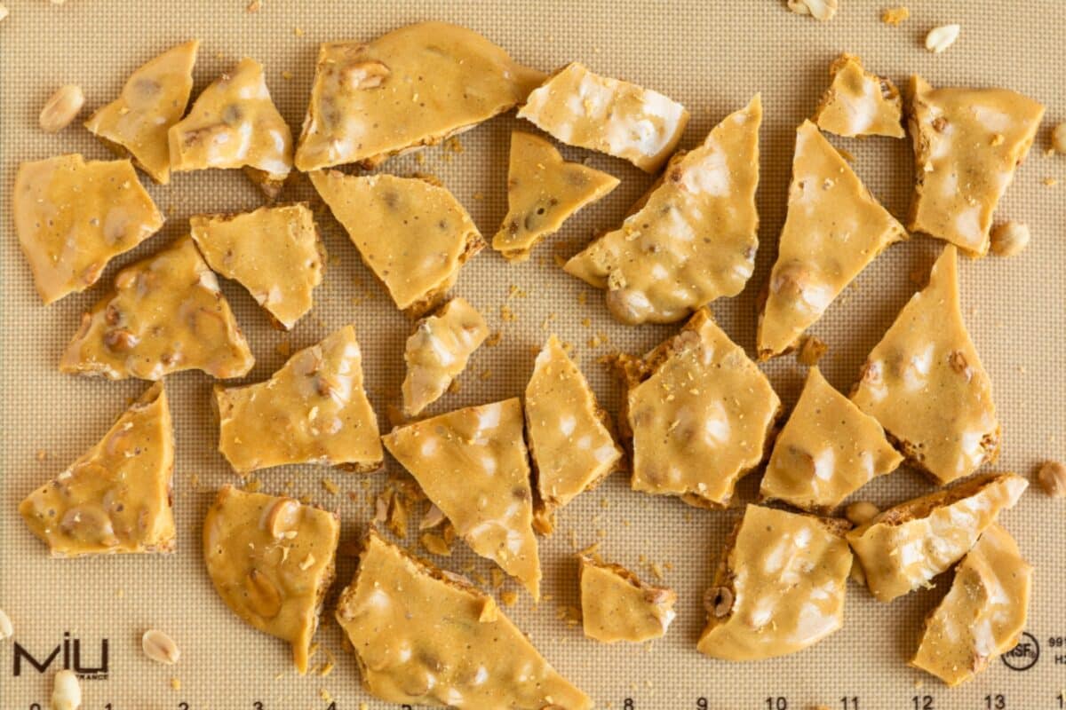 A silicone mat full of shards of peanut brittle.
