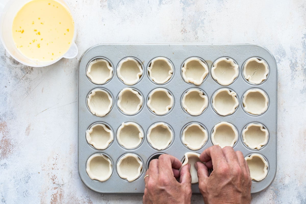Pie crust pressed into a mini muffin tin.