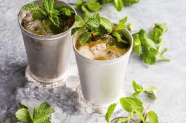 Two mint juleps in silver cups.