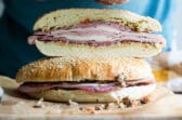 Muffaletta sandwiches on a wooden cutting board.