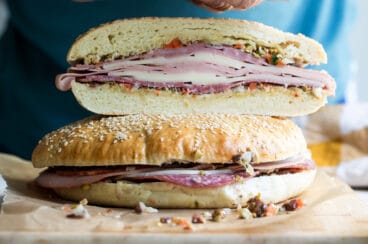 Muffaletta sandwiches on a wooden cutting board.