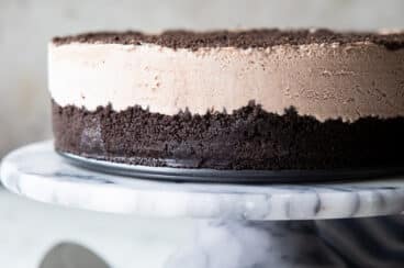 Frosty cheesecake on a marble serving platter.