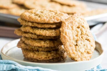 Oatmeal scotchies stacked on a white plate.