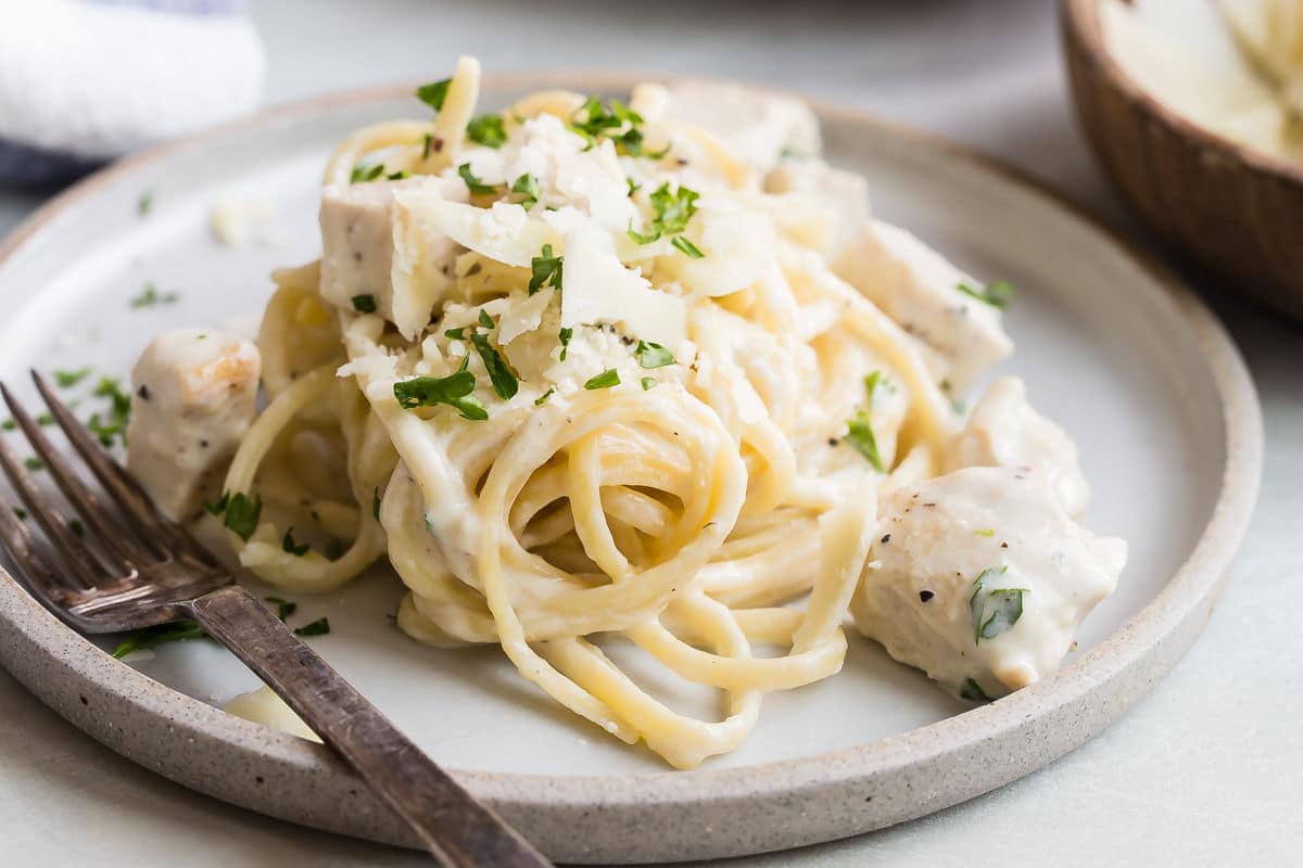 Two plates of chicken alfredo.
