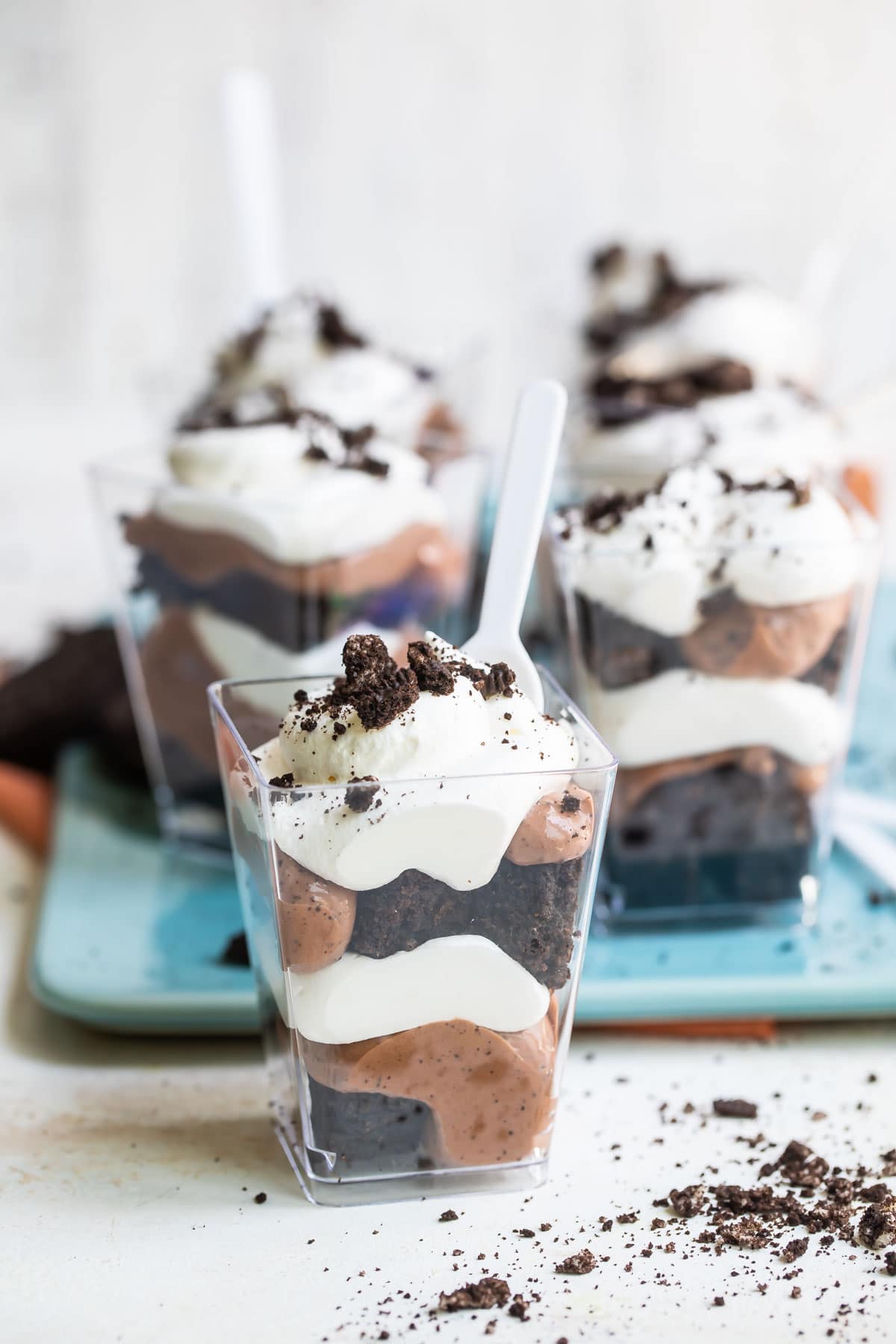 Miniature Oreo brownie trifles in small clear plastic cups.