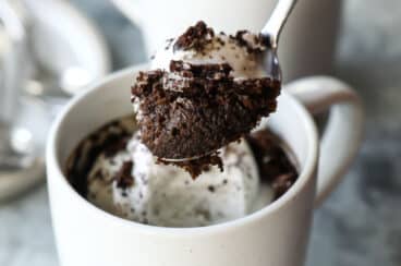 Two Oreo mug cakes topped with a whole oreo.