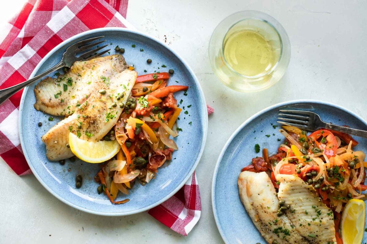 Two plates of pan fried tilapia.