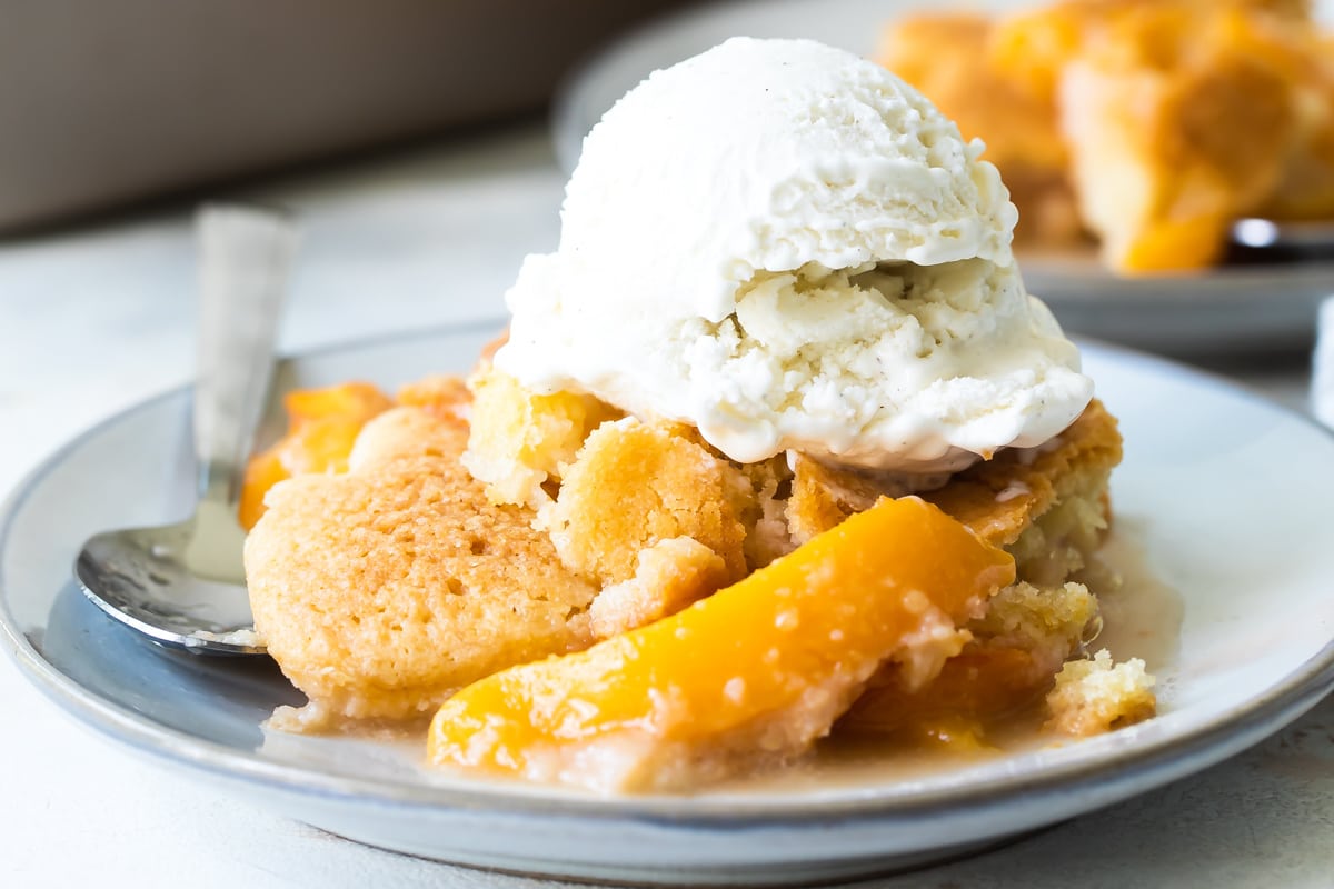 A plate of peach cobbler with vanilla ice cream.