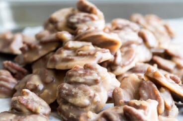 A stack of pecan pralines on a baking sheet.
