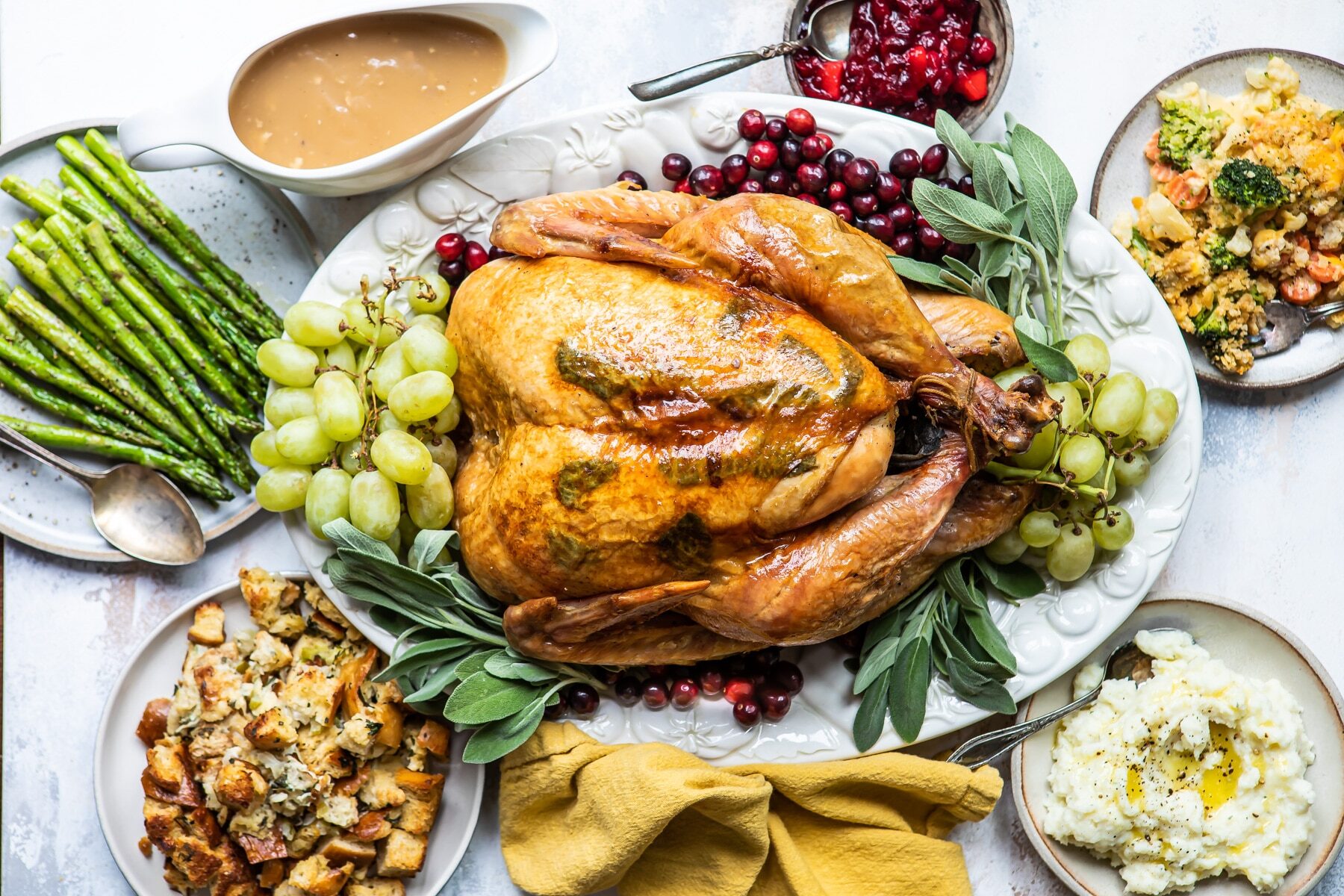 A roasted turkey on a platter with fruit.