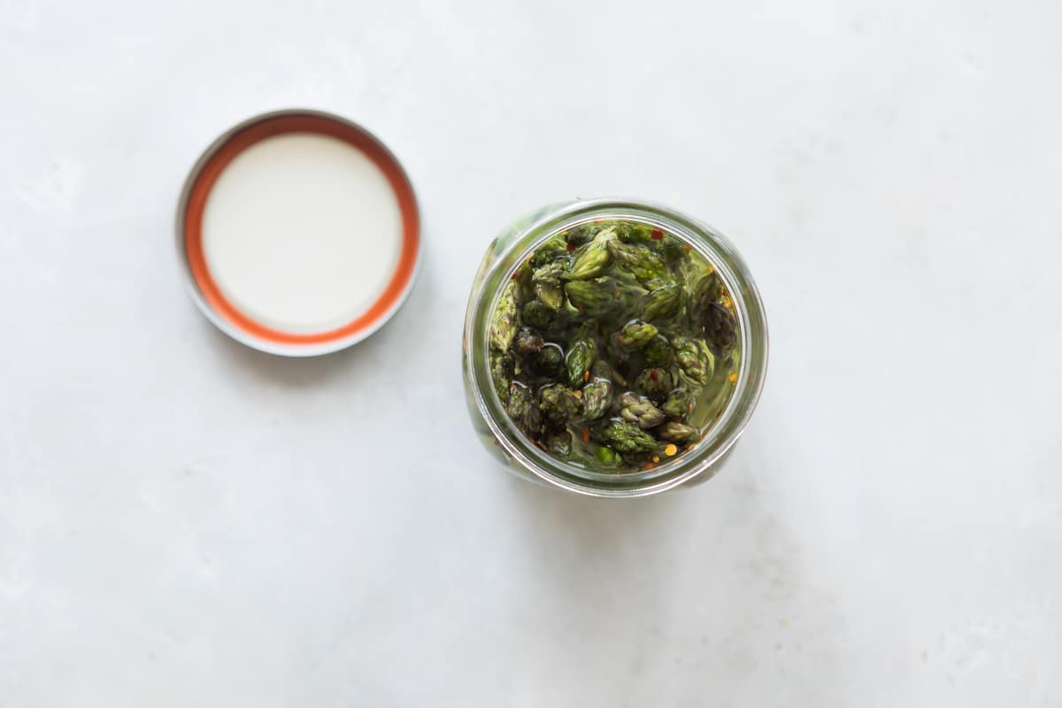 Pickled asparagus in a jar with the lid removed.